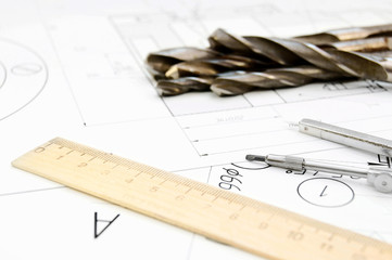 Drills, a compasses and a ruler on the drawing.