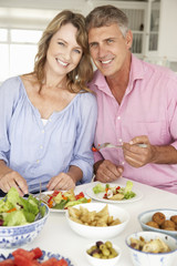 Obraz na płótnie Canvas Mid age couple enjoying meal at home