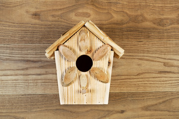 Obraz na płótnie Canvas New Wooden Birdhouse on Rustic Wood Boards