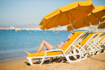 Girl relaxing on a beach chair near the sea