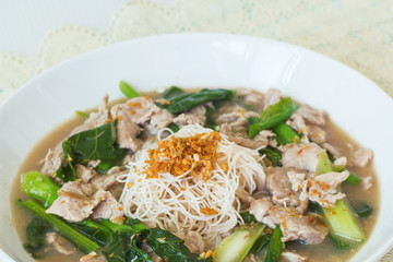 vermicelli  noodles topped with pork and kale