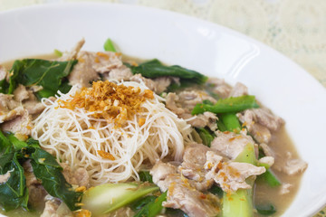 vermicelli  noodles topped with pork and kale