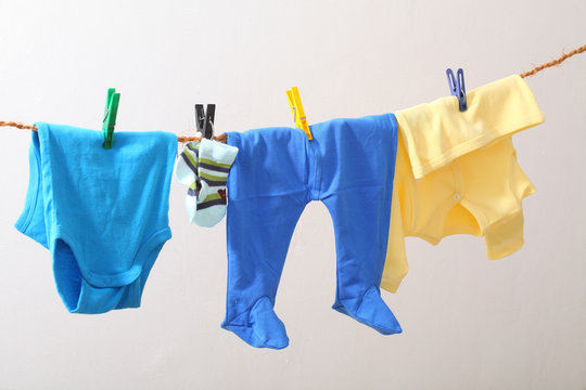 Baby clothes drying on rope. Kids underwear on white backgroud