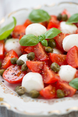 Caprese salad on a glass plate, close-up, vertical shot