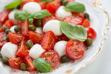 Glass plate with caprese salad, horizontal shot