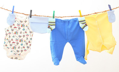 Baby clothes drying on rope. Kids underwear on white backgroud