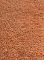 Texture of the red rough plastered wall