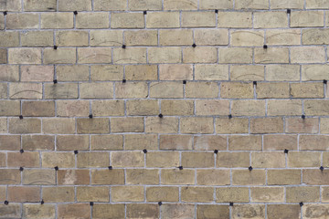 The creative gray brick wall with pig-iron rivets as background