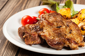 Steaks, baked potatoes and vegetable salad