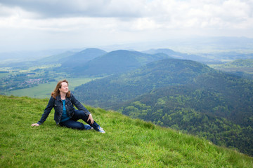 Girl sitting on the slope of volcano in Auvergne
