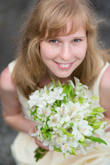 Young bride holding in her hands wedding flowers