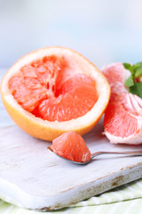 Ripe grapefruits on cutting board, on wooden background