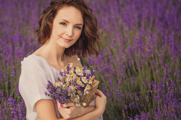 Smiling beautiful brunette in the lavender field