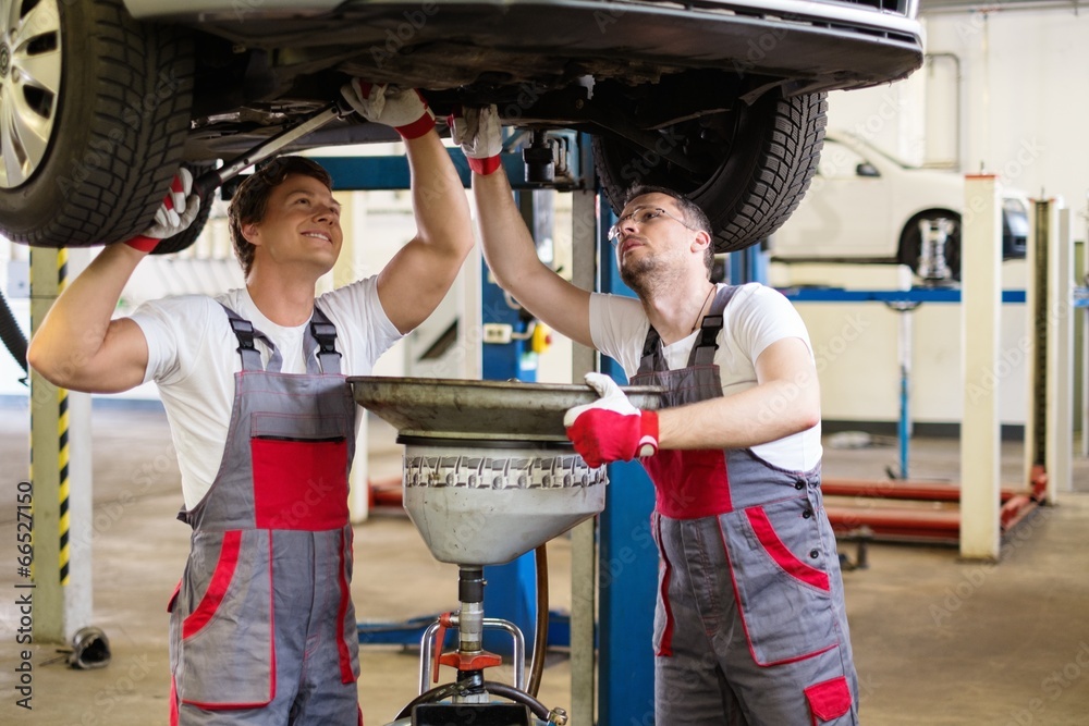 Sticker Two mechanics changing oil  in a car workshop