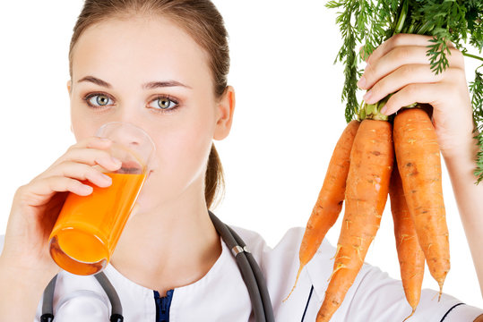 Female doctor holding healthy carrots.