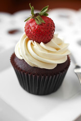 close up chocolate cup cake and strawberry on white table