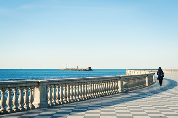 Solitary woman walking on Mascagni terrace in front of the sea,
