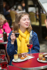 Girl drinking coffee and wine in a cafe