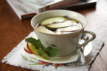 close up red tea and apple in ceramic cup