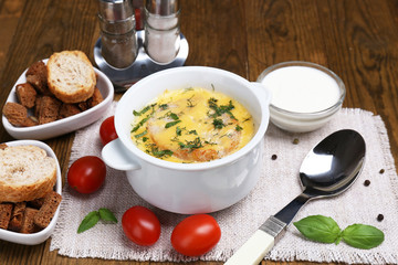 Tasty soup in saucepan on wooden table, close up