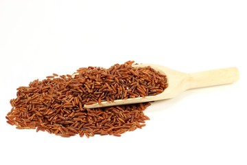 Roter Reis mit Holzlöffel isoliert auf weißem Hintergrund