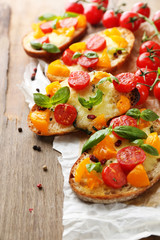 Tasty bruschetta with tomatoes, on old wooden table