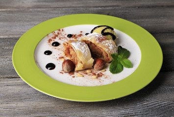 Tasty homemade apple strudel with nuts, mint leaves and