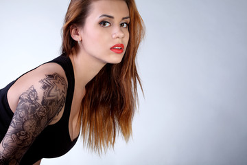 Молодая девушка с татуировкой на руке - obrazy, fototapety, plakaty