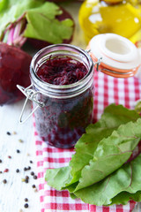Grated beetroots in jar on table close-up