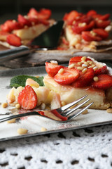 Piece of strawberry tart on  tray, on rustic wooden background