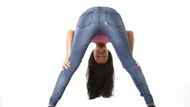 Back view of young woman in tight jeans bending over and smiling
