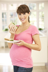 Pregnant woman eating sandwich