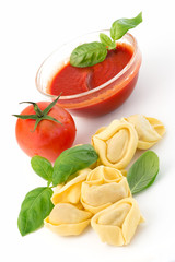 Tortellini, tomato sauce and basil leaves