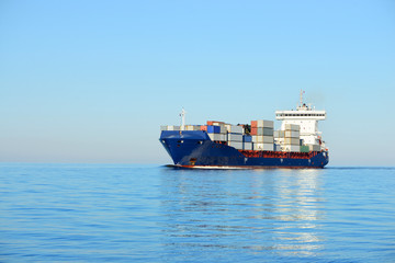 Large cargo container ship sailing in a bright sunny day. Riga,