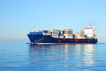 Large cargo container ship sailing in a bright sunny day. Riga,