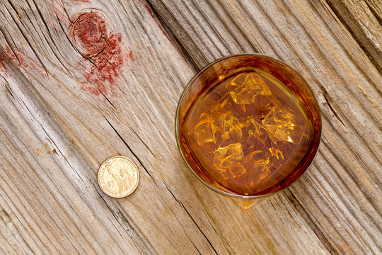 Glass of whiskey and a coin on a bar counter