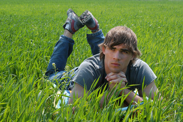 Naklejka na ściany i meble Sexy young man on green grass