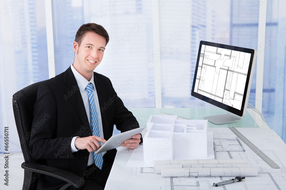 Poster Architect Using Digital Tablet At Computer Desk