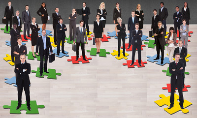 Business People Standing On Jigsaw Pieces