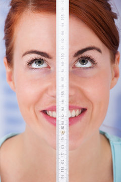 Woman Measuring Height With Measure Tape