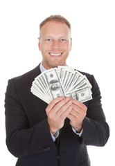 Smiling Businessman Holding Bank Notes