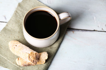 Cup with hot coffee and roasted coffee grains