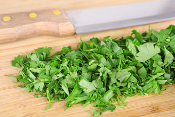 Chopped greens with knife on cutting board