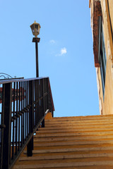 Vintage stairs with a light pole and sky.