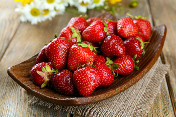 Ripe sweet strawberries on plate on table close-up