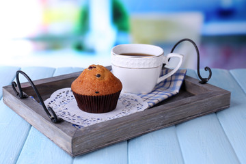 Blueberry muffin and coffee on tray, on wooden background