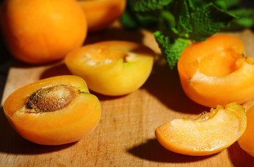 Ripe apricots with green mint leaves