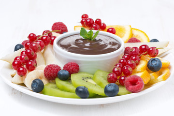 assorted fruit with chocolate sauce on a plate, close-up