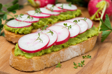ciabatta with pate of avocado and fresh radish, close-up