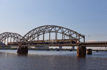 Fototapeta na wymiar Train on the bridge over Daugava River. Riga, Latvia